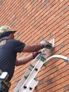 Animal removal technician sealing a home